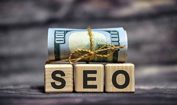 istock SEO - text on wooden cubes with dollars 100 bills 2218017685