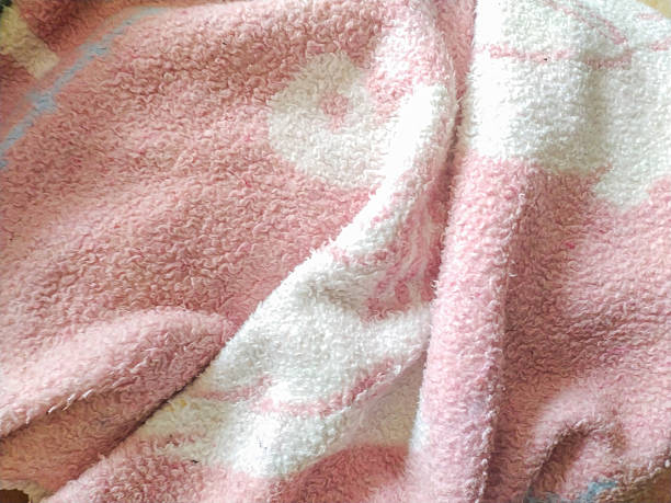 Soft pink and white towel, closeup. Fabric texture for backgrounds, design elements. Warm, comforting, soothing. Ideal for home, baby, or spa themes.