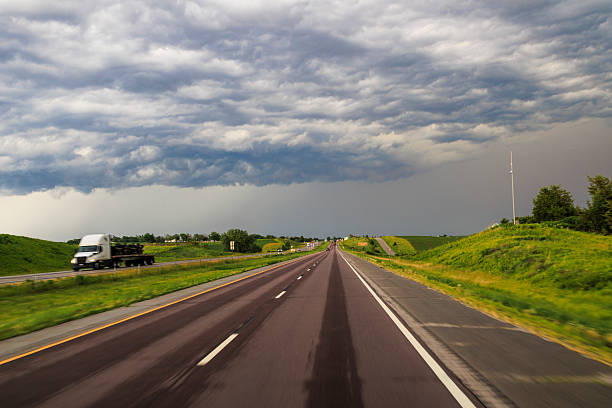 Cloudy skies loom over Iowa highway as driver navigates road before a storm hits