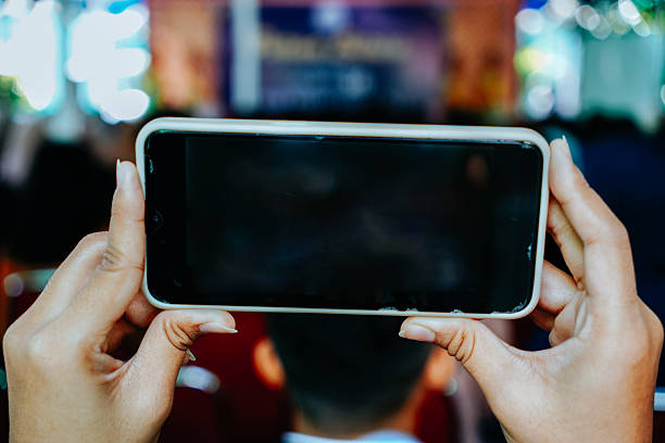 istock close up of hand holding smart phone while recording at an event 2218031380