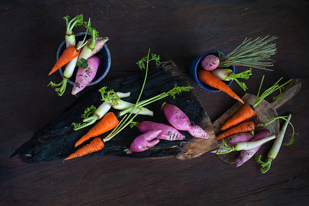 Roots vegetable, fresh and colorful arrange on dark drift wood, blue ceramic background on rustic dark backround