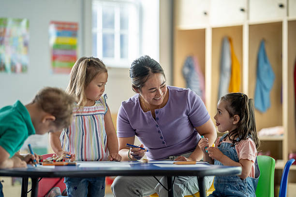 istock Teacher Interacting With Young Children in a Playroom Setting 2218038541