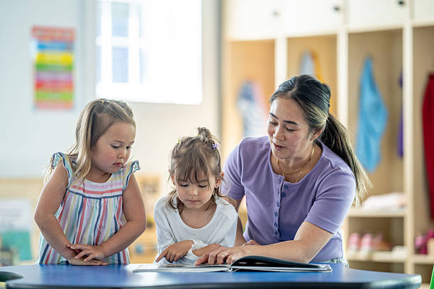 istock Teacher Assisting Young Children in Educational Activity at Daycare 2218038563