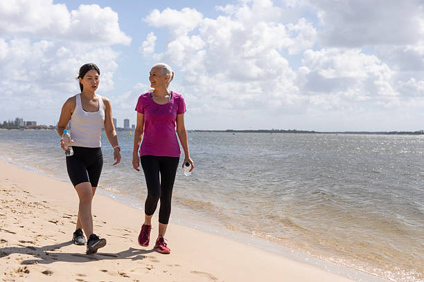 istock Active women walking by the beach 2218045548