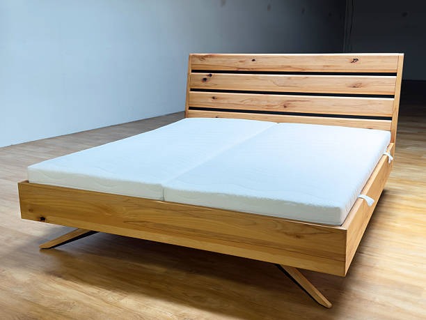 istock Sleek modern wooden bed frame with minimalist design in spacious room 2218046833