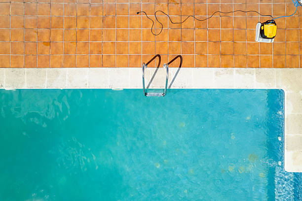 swimming pool with clear blue water and cleaning equipment aerial, aerial directly above drone view