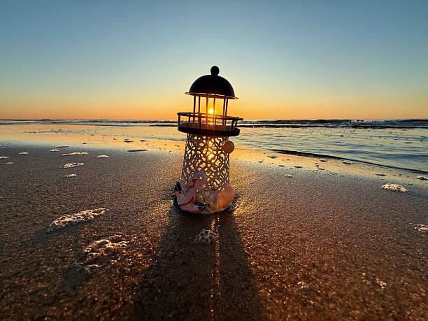 istock handmade tin lighthouse by the sea, captured during a stunning sunset. 2218051860