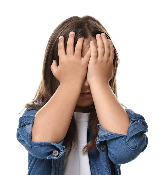 istock Scared little girl covering face with hands on white background 2218054853