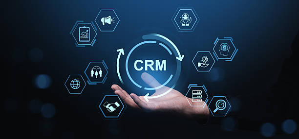 istock CRM concept with glowing digital interface icons above a person's hand on dark blue background symbolizing business automation and customer relationship management. 2218055946