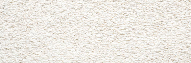 istock White new fluffy home carpet background. Closeup. Wide banner. Empty place for text. Top down view. 2218055952