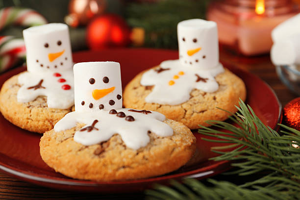 istock Funny marshmallow snowmen, cookies and festive decor on table, closeup 2218056089