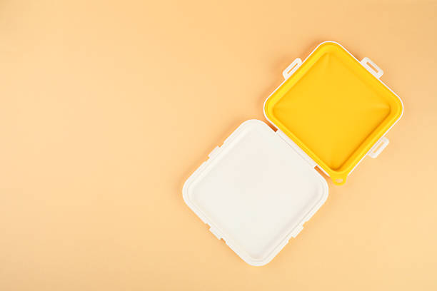Plastic sandwich lunch box on peach background, top view. Space for text