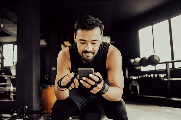 istock Handsome Young Asian Man using smartphone during training. Athlete man cardio and wo 2218056522