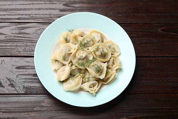 istock Delicious pelmeni with dill on wooden table, top view 2218056571