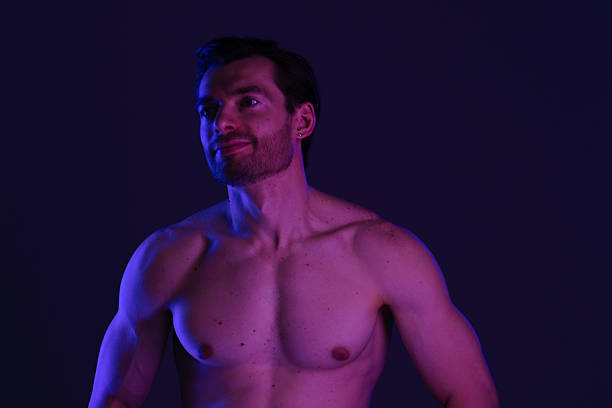 istock Muscular Man Posing in Purple Lighting with Towel 2218059558