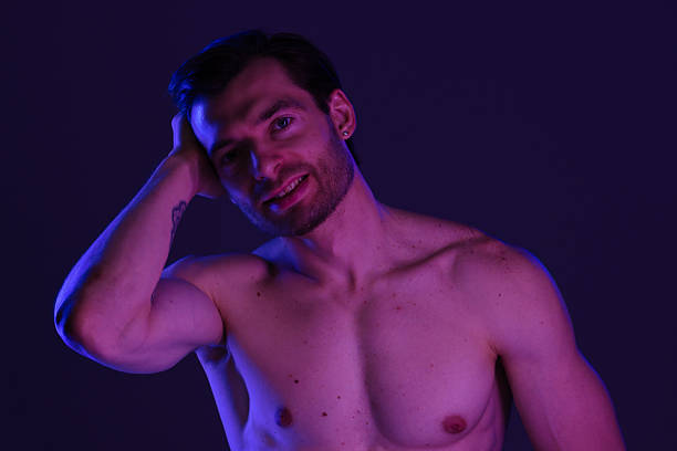 istock Muscular Man Posing in Purple Lighting with Towel 2218060160
