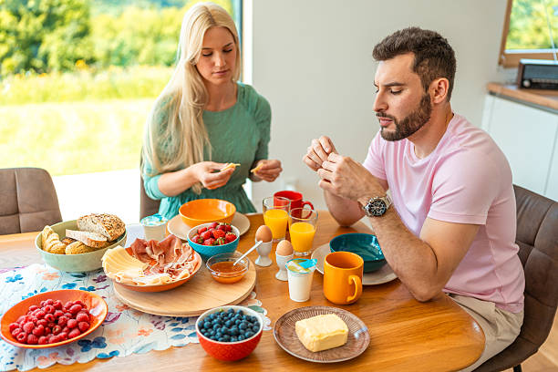 istock Young Couple Enjoying Nutritious Breakfast at Bright Kitchen Table with Fresh Fruits and Juice 2218065175
