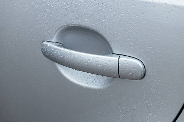 car door handle, water drops on the silver metal surface, abstract background, macro drops after the rain, grey car after carwash