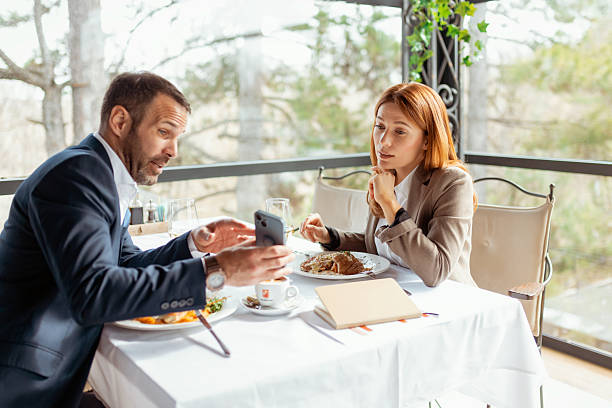 istock Corporate Partners Discussing Financial Plans Over Dinner with Smartphone 2218067534