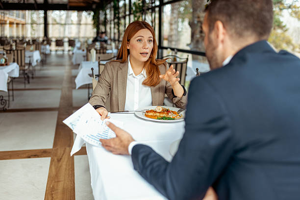 istock Male and Female Executives Working Together at Upscale Lunch Table 2218067807