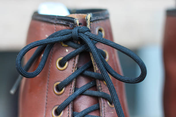 Cropped shot of an unrecognizable mature bridegroom adjusting his shoelaces while preparing fir his wedding outdoors