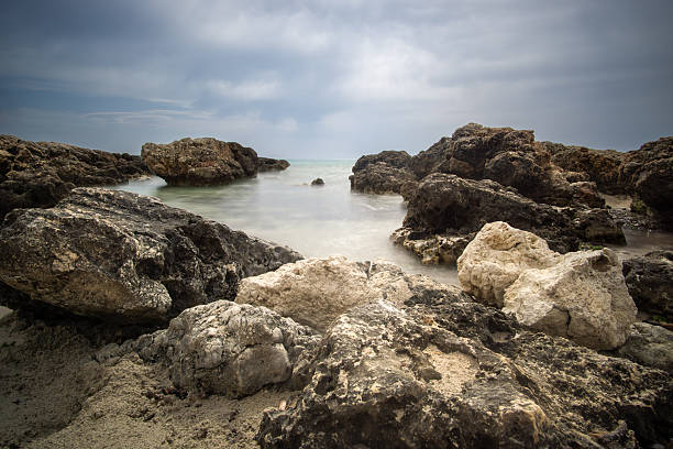 istock Rugged coastline with rocky formations and tranquil waters under a moody sky during overcast weather 2218068466