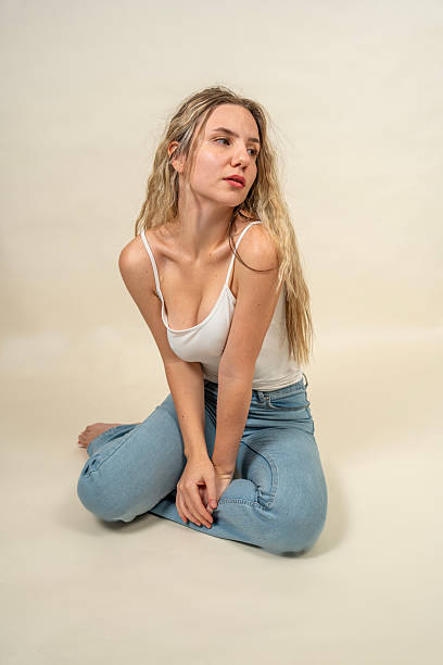 istock Young woman sitting on floor looking away from camera 2218075190