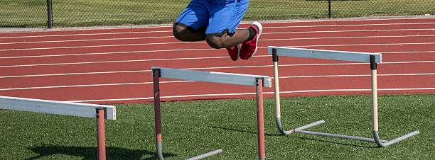 istock Young Athlete Practices Jumping Over Hurdles on Training Track 2218076299
