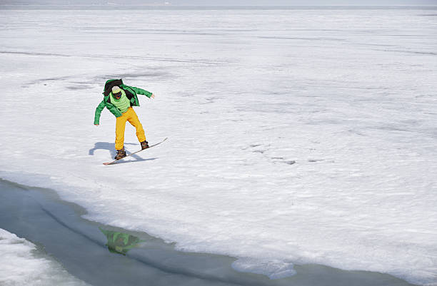 Snowboarder descends mountain at ski resort on a blue sky day, Swiss Alps