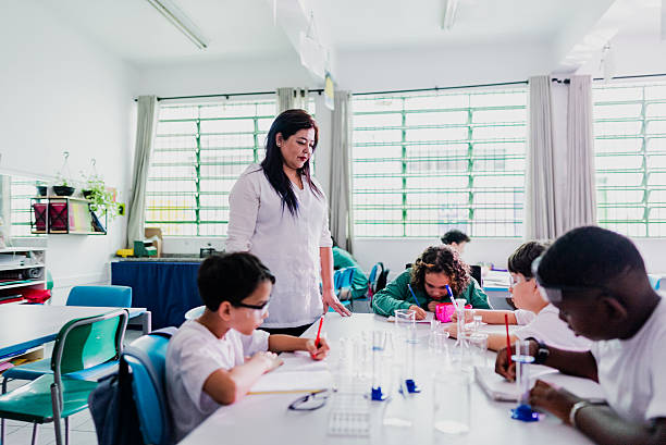 istock Teacher helping students with scientific experiment in the classroom 2218083426