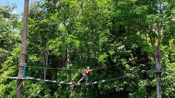 istock A man is walking across a challenging ropes course in the extreme park 2218084725