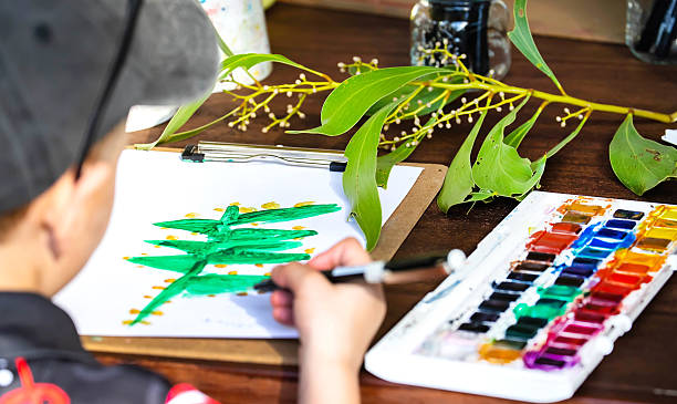 istock Child painting eucalyptus leaf with watercolors during nature art activity 2218088918