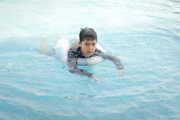 Teenage boy in a swimming pool on a float