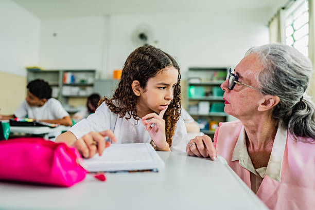 istock Mature teacher assisting student at classroom 2218092202