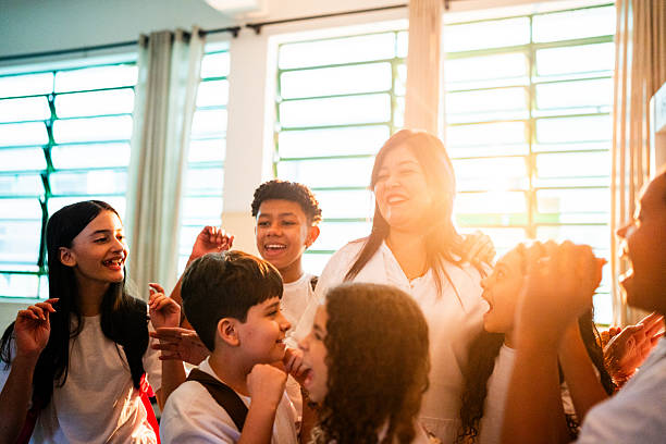 Mature teacher having fun with students at classroom
