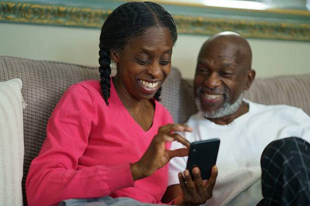 istock Senior Couple Smiling While Using a Smartphone Together on a Cozy Couch 2218094026