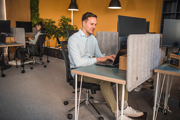 istock Handsome business man sitting at desk in co-working space and working on computer 2218094455
