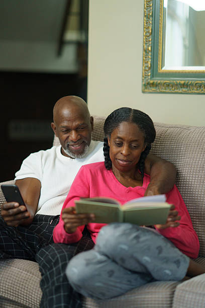 istock Couple Relaxing Together Reading and Using a Smartphone at Home 2218094803