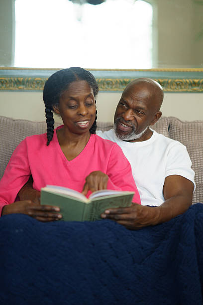 istock Happy Senior Couple Reading Together at Home Relaxing on Sofa 2218095132