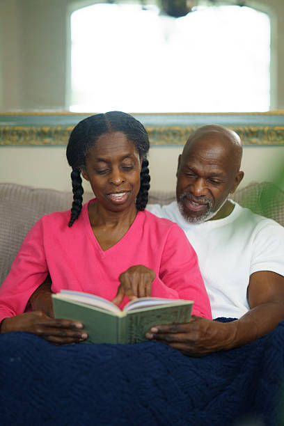 istock Senior Couple Bonding While Reading Together on a Comfortable Couch 2218095134