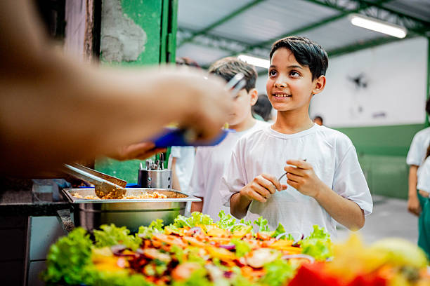 istock Schoolboy receiving lunch at school cafeteria 2218098748