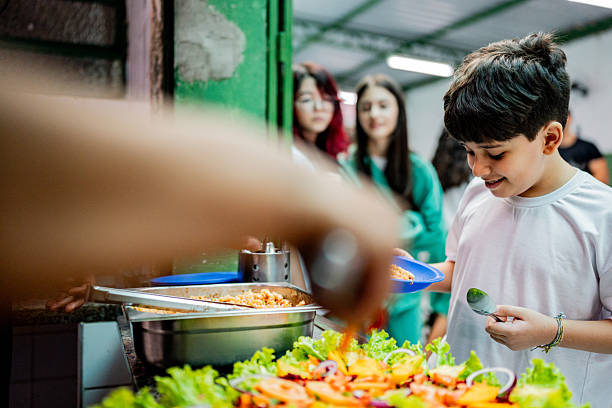 istock Schoolboy receiving lunch at school cafeteria 2218098780