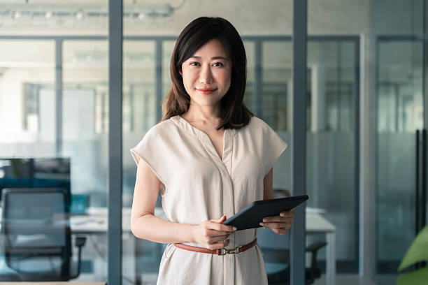 istock Portrait at camera Asian mature woman ceo analyst manager using tablet for business work, learning or communication. Smiling entrepreneur businesswoman leader holding touchscreen pc device in office 2218098863