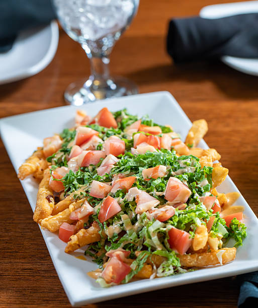 Loaded fries topped with chopped tomatoes and lettuce