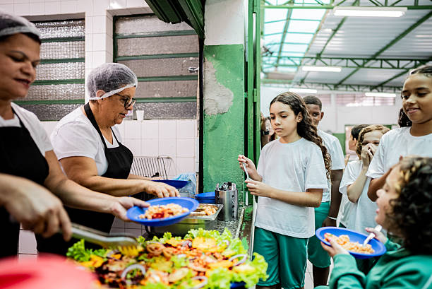 istock School cooks serving students during lunch break in the cafeteria at school 2218099036