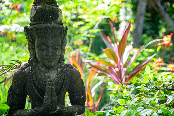 Balinese statue in a garden with lush plants