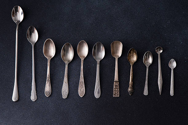 istock Set of different spoons. Silver cutlery on a black background. Spoon on the table 2218102396