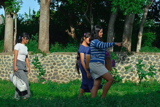 As they explore the open field, a girl gestures toward a flat patch of grass while the group considers whether itG??s suitable for their campsite.