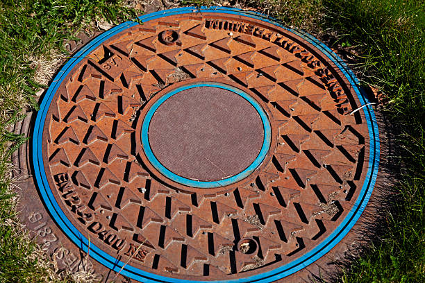 istock Distinctive Blue-Rimmed Manhole Cover on Grass 2218105629