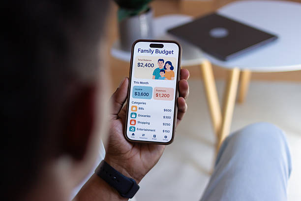 istock Man managing family budget using mobile phone app at home 2218107608